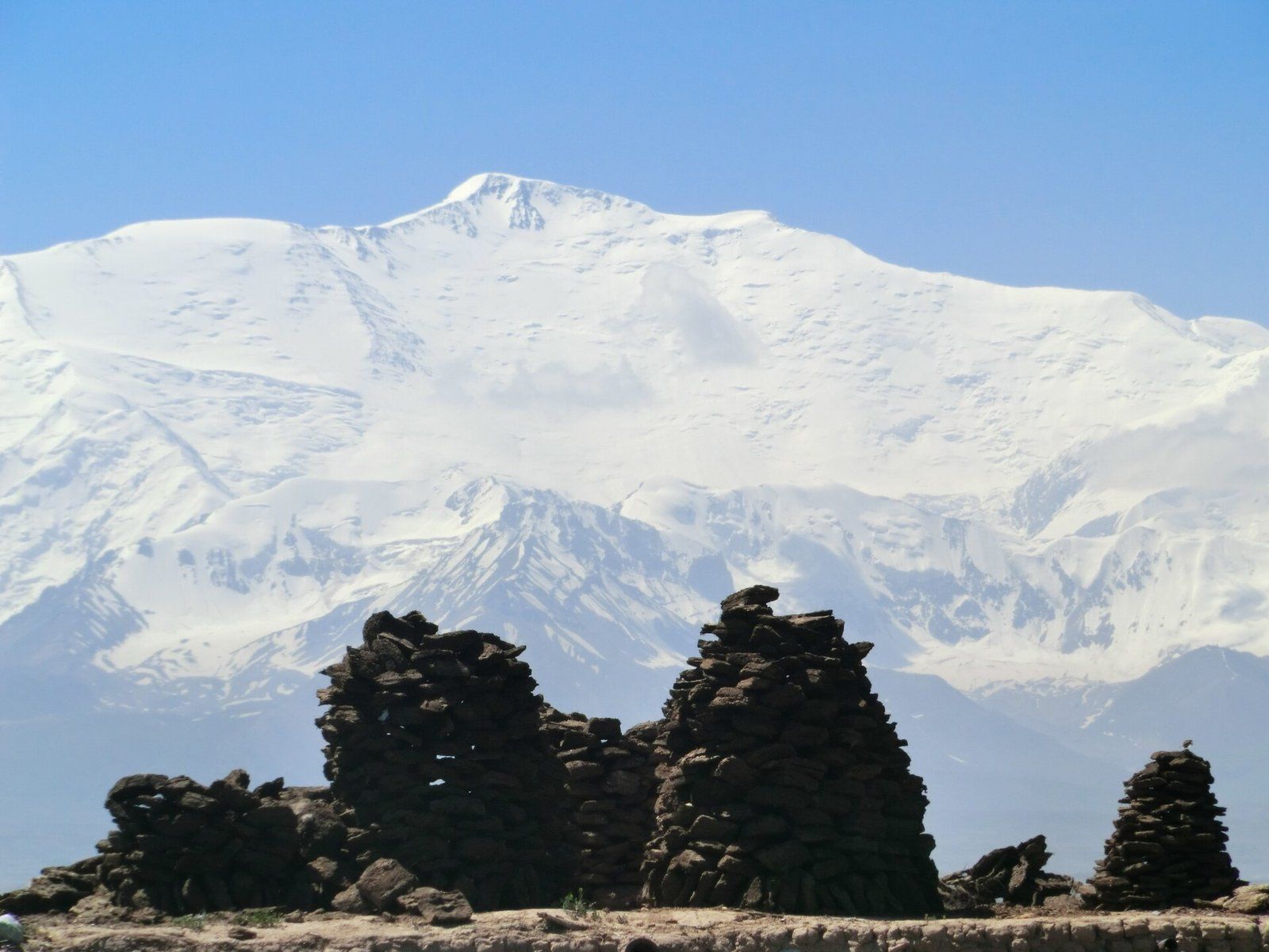 The snow-covered mass of Lenin Peak rising above the Alay range.